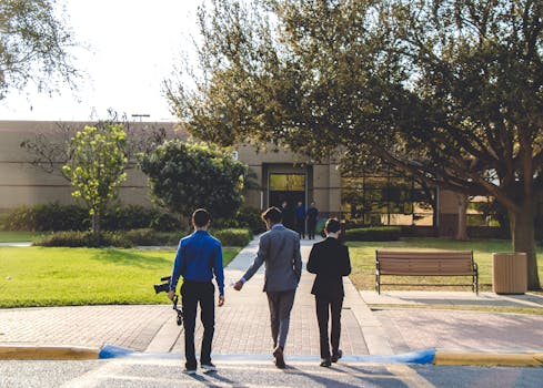 三名成年人走向德克萨斯州梅赛德斯一栋树木环绕、绿化茂密的建筑