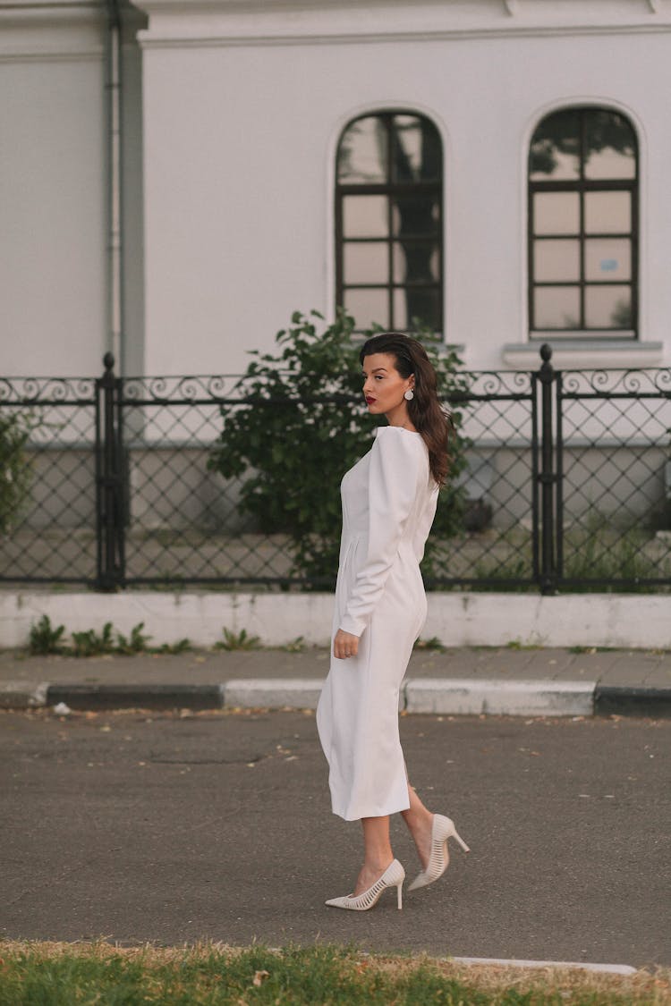 Woman In White Dress And High Heels Walking On Road