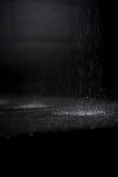 Close-up of water droplets against a black background, creating a dramatic abstract scene.