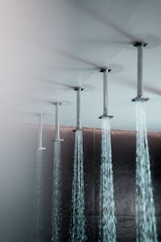 Ceiling-mounted rain showers with water streaming, creating a luxurious bathroom experience.