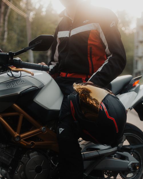 Free Close-up of a motorcyclist sitting on a bike, holding a helmet in Saint Petersburg. Stock Photo