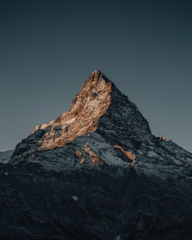Breathtaking view of a snow-capped mountain peak at sunset in Dombay, Russia.