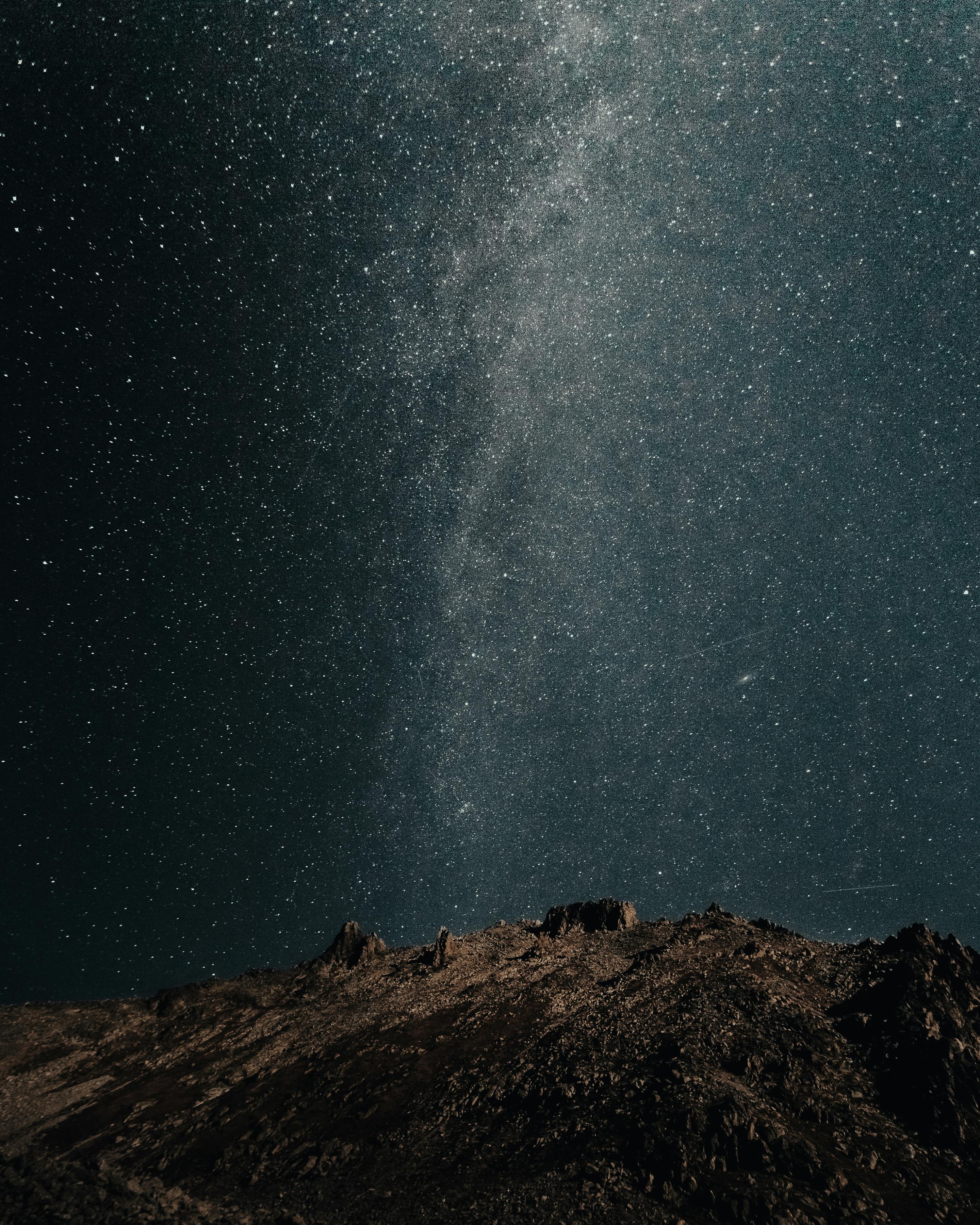 photo of mountain under starry night sky