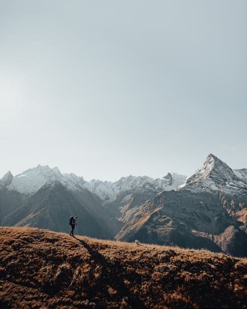 Free Drone Shot of a Man Walking on top of a Mountain  Stock Photo
