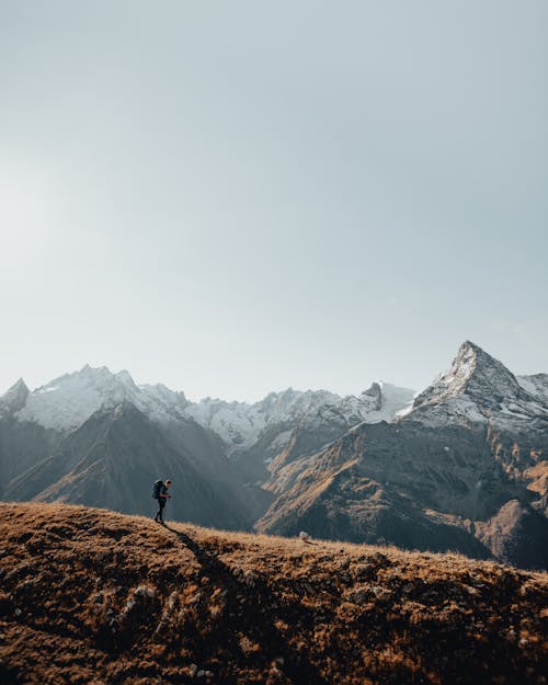 Drone Shot of a Man Walking on top of a Mountain 