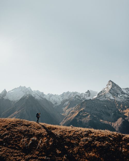 Free Hiker explores the dramatic, scenic mountains of the Caucasus under a clear sky, capturing adventure and wanderlust. Stock Photo