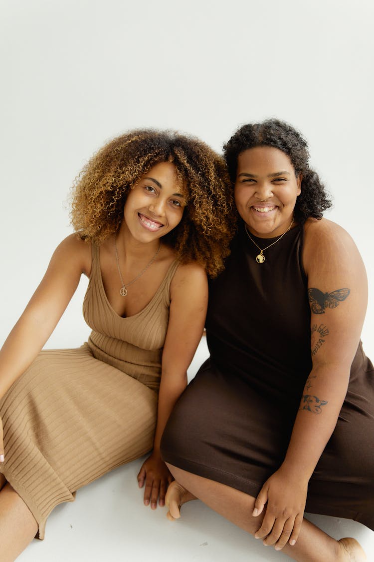 Smiling Women Sitting On White Background