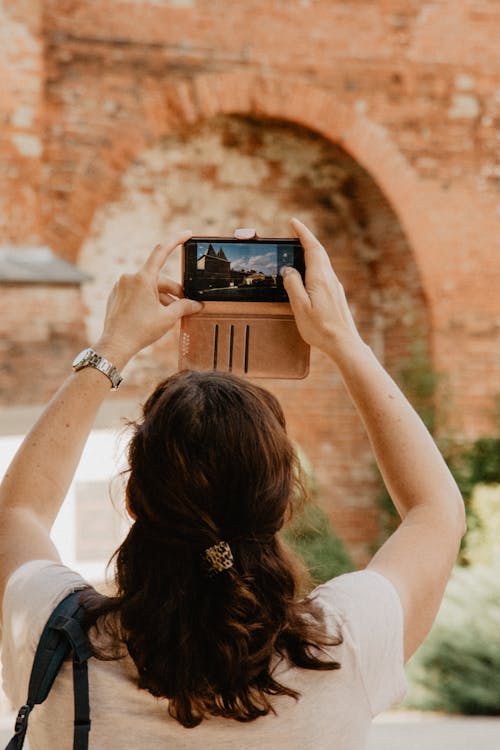 A Woman Taking a Photo Using Her Mobile Phone