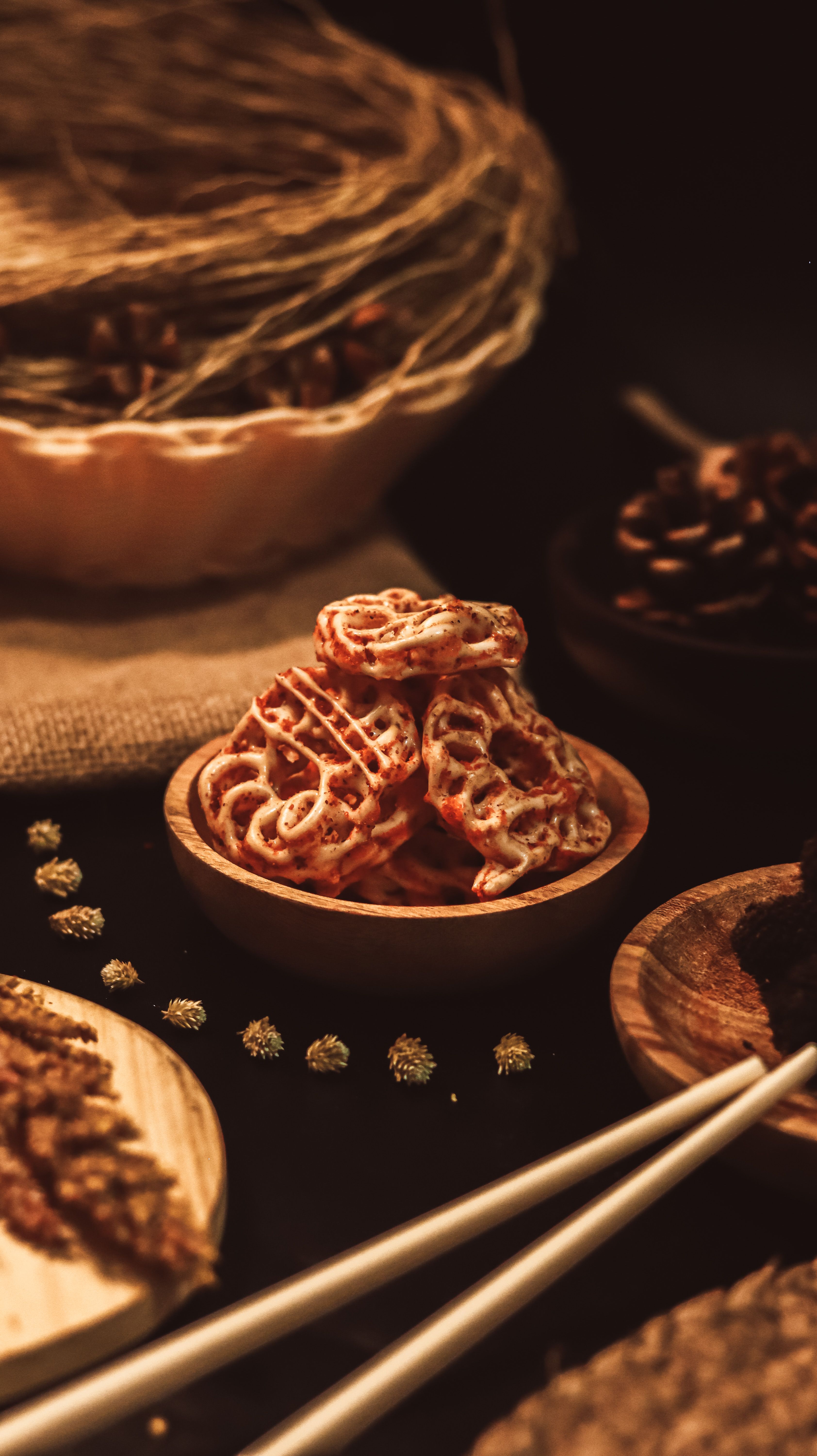 A close-up of crispy Asian snacks in bowls, artfully arranged with chopsticks. - Fotografer Sidoarjo