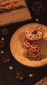 Close-up of spiral-shaped snacks arranged on a wooden plate, capturing a rustic and tasty presentation.