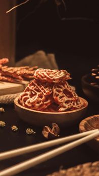 A cozy image of crispy waffles in a wooden bowl, captured in warm lighting.