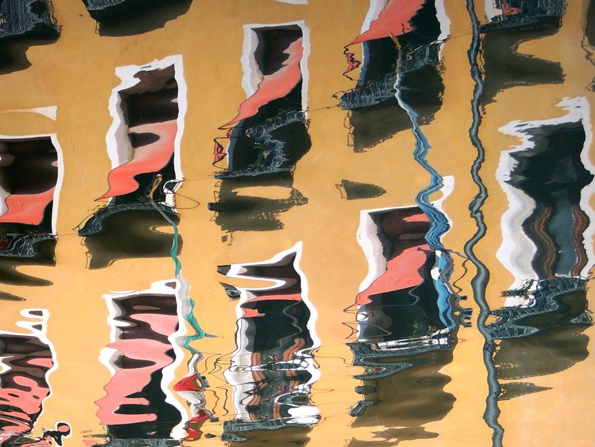 Artistic reflection of colorful Venetian building facades in water.