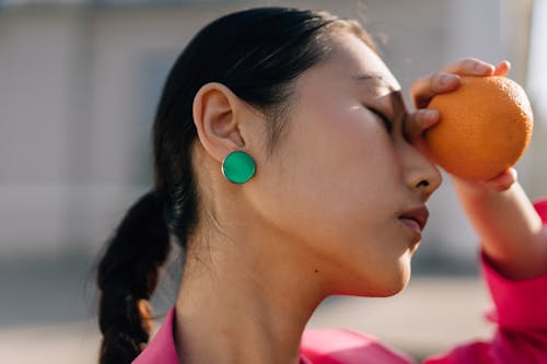 Free Close Up Photo of a Woman Holding an Orange Stock Photo