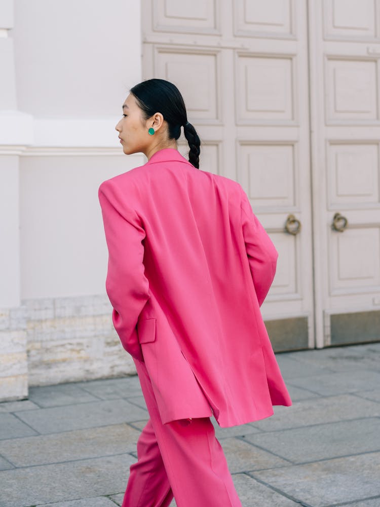 A Young Woman In Pick Clothes Walking Towards The Doorway