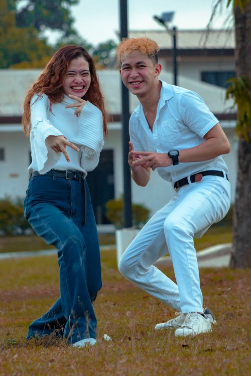 Free Two friends joyfully posing outdoors in playful outfits. Stock Photo