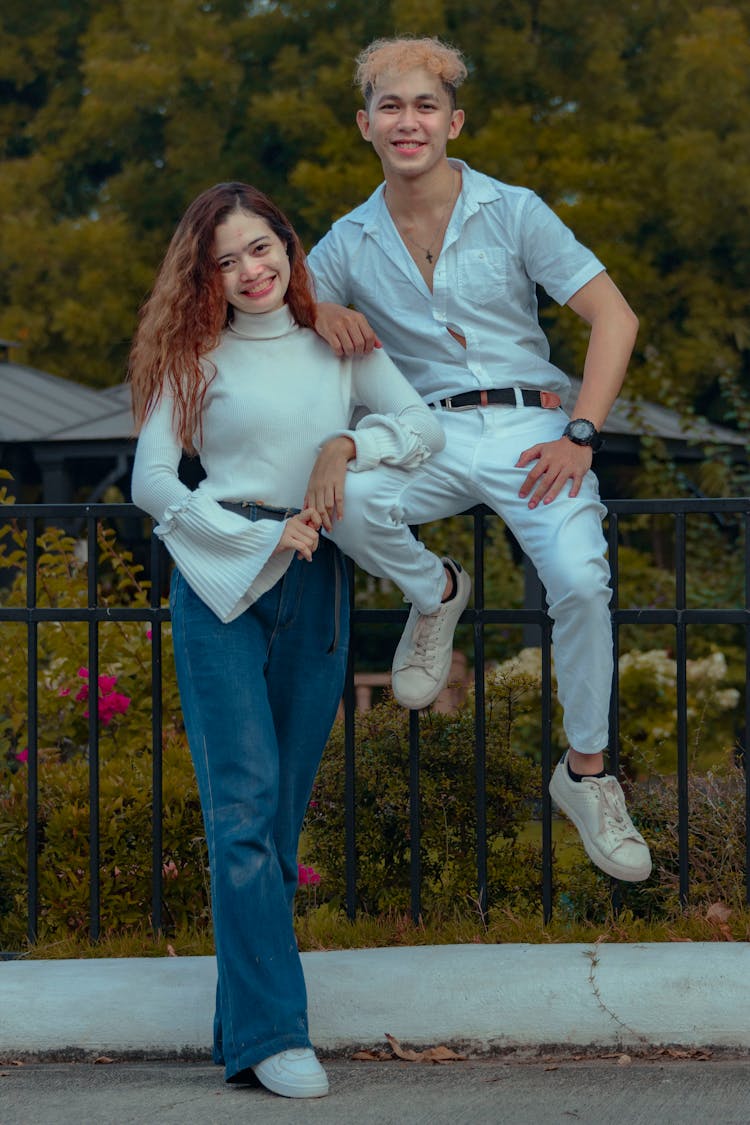 Young Couple Posing For Photo With Park In Background