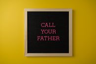 Minimalist letter board with message on vibrant yellow background for Father's Day reminder.