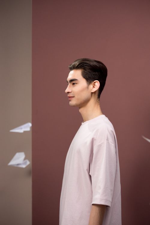 Free Stylish portrait of a man surrounded by paper airplanes, showcasing fashion and creativity. Stock Photo