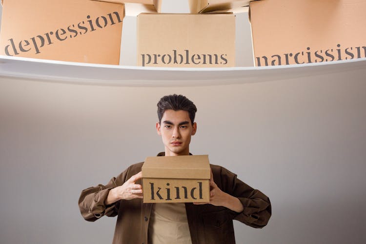 A Man Holding A Box With Kind