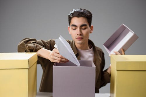 Free A Man Putting Paper Airplane in the Box Stock Photo