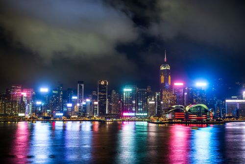Free A captivating view of Hong Kong's vibrant skyline reflecting in Victoria Harbour at night. Stock Photo