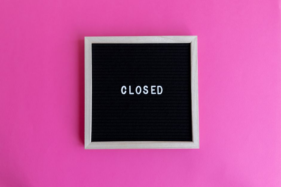 Photo by Jorge Urosa A minimalist blackboard sign with 'CLOSED' text on a vibrant pink background.