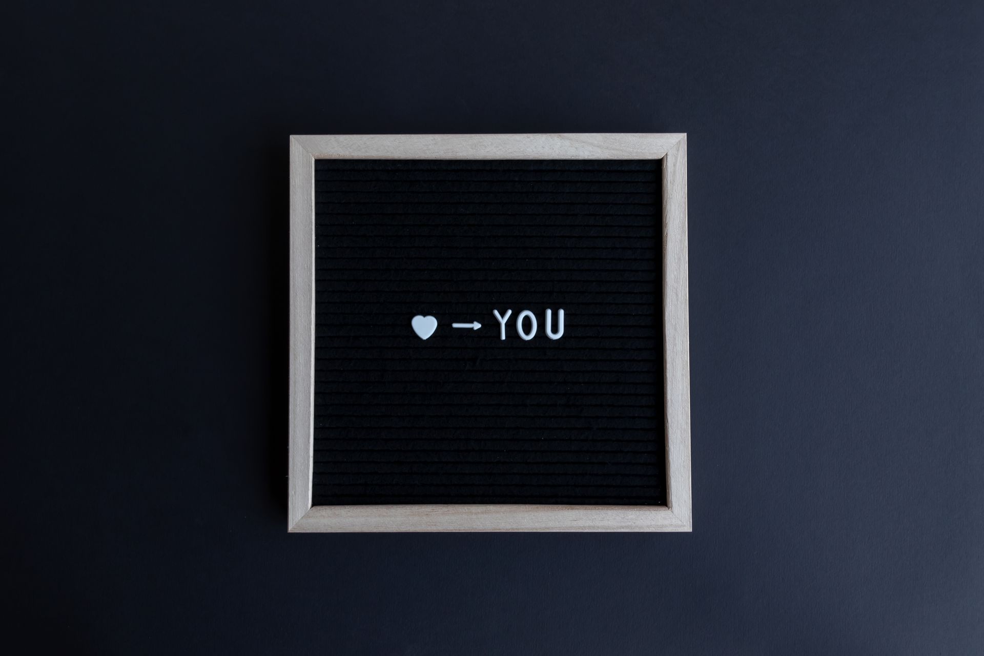 A simple letter board with a heart icon and text 'heart you' on a black background.
