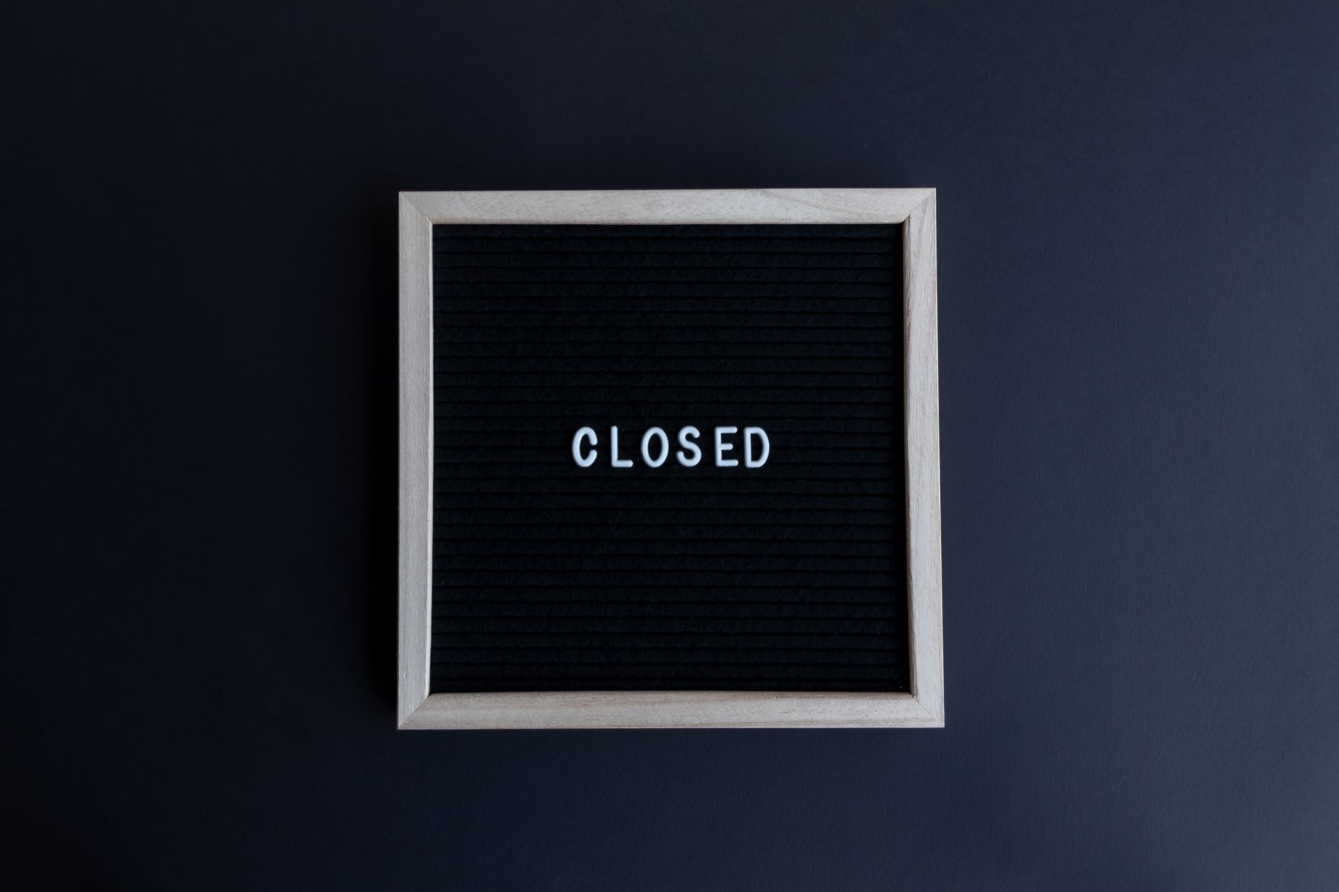 Black letter board with the word 'CLOSED' in white on a dark background.