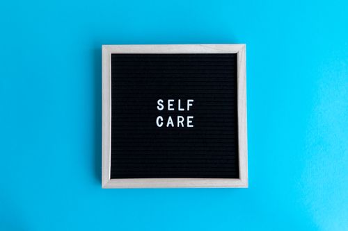 Free A framed letter board with 'Self Care' text on a vibrant blue background for positivity. Stock Photo