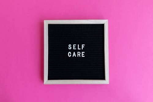Self Care Text on a Letter Board on a Pink Background 