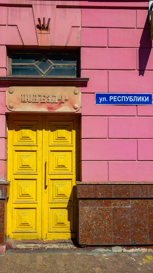 A Yellow Door of a Pink Hotel Building