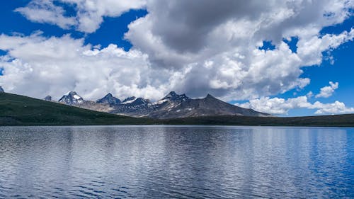 Scenic View of Mountains Under White Clouds