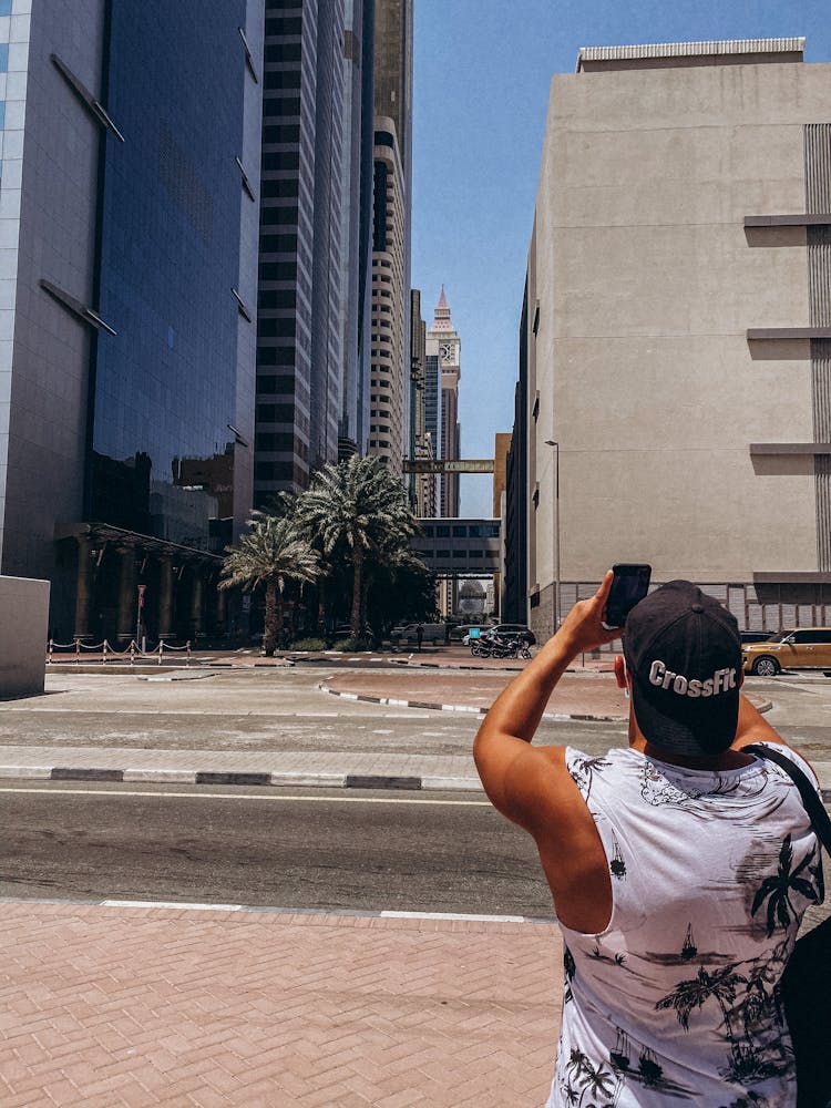 Man Taking A Photo Of Skyscrapers