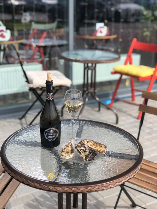 Free A bottle of champagne with a glass and oysters on an outdoor café table in Tyumen, Russia. Stock Photo