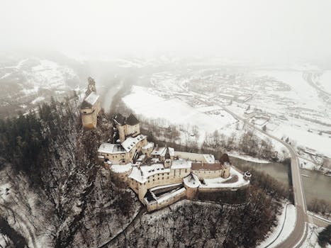 Drone shot of Orava Castle in a snowy landscape, showcasing medieval architecture.