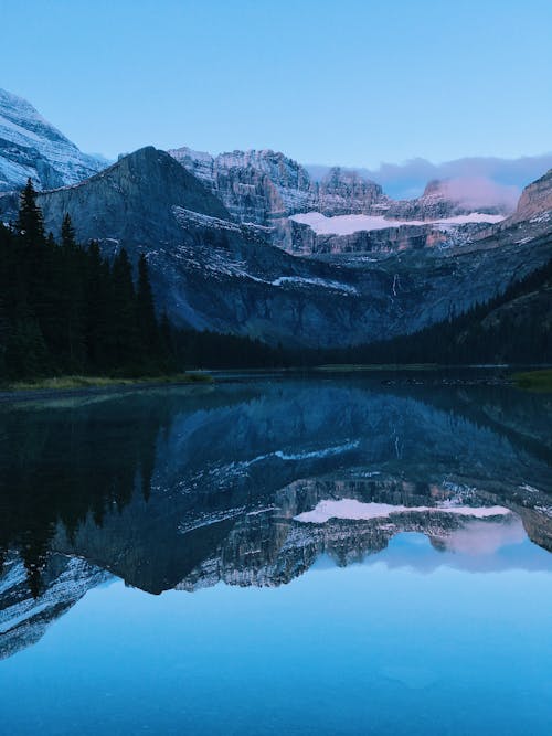 Mountain and Trees Reflection over the Lake Surface