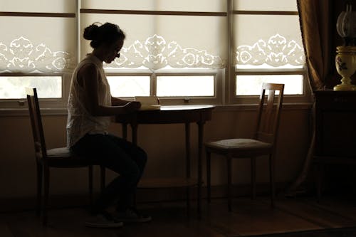 Side View of a Woman Sitting at the Table 