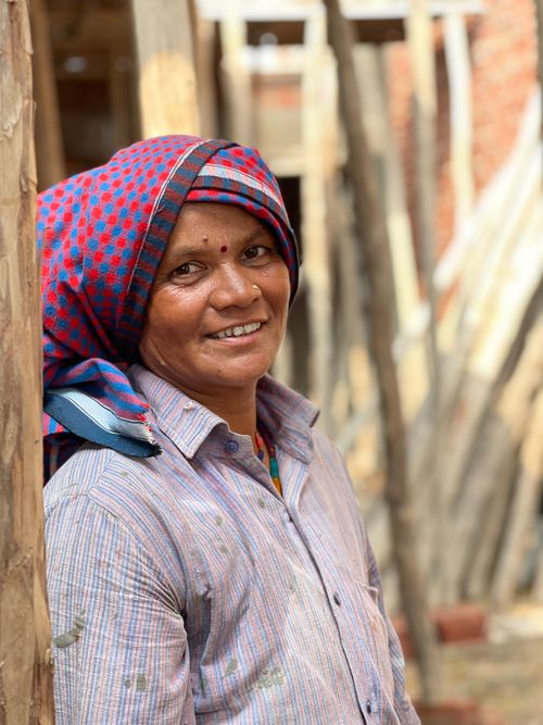 Free Portrait of a smiling woman in a traditional headscarf and button-up shirt outdoors in India. Stock Photo