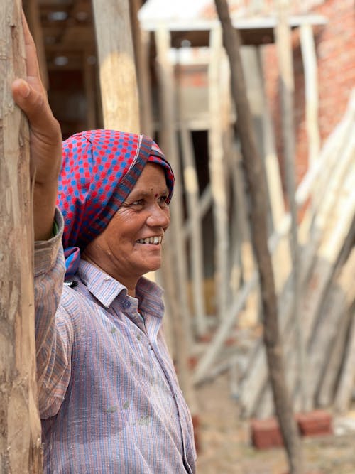 A Woman with Smiling Face Standing Beside Brown Wooden Post