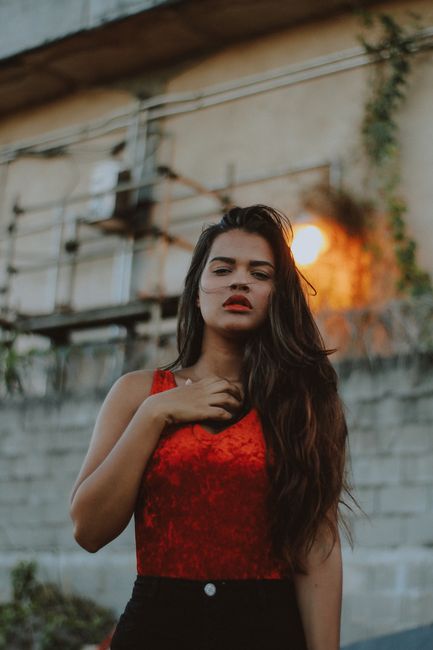 A striking portrait of a woman with long hair in outdoor setting, highlighting her expression and style.