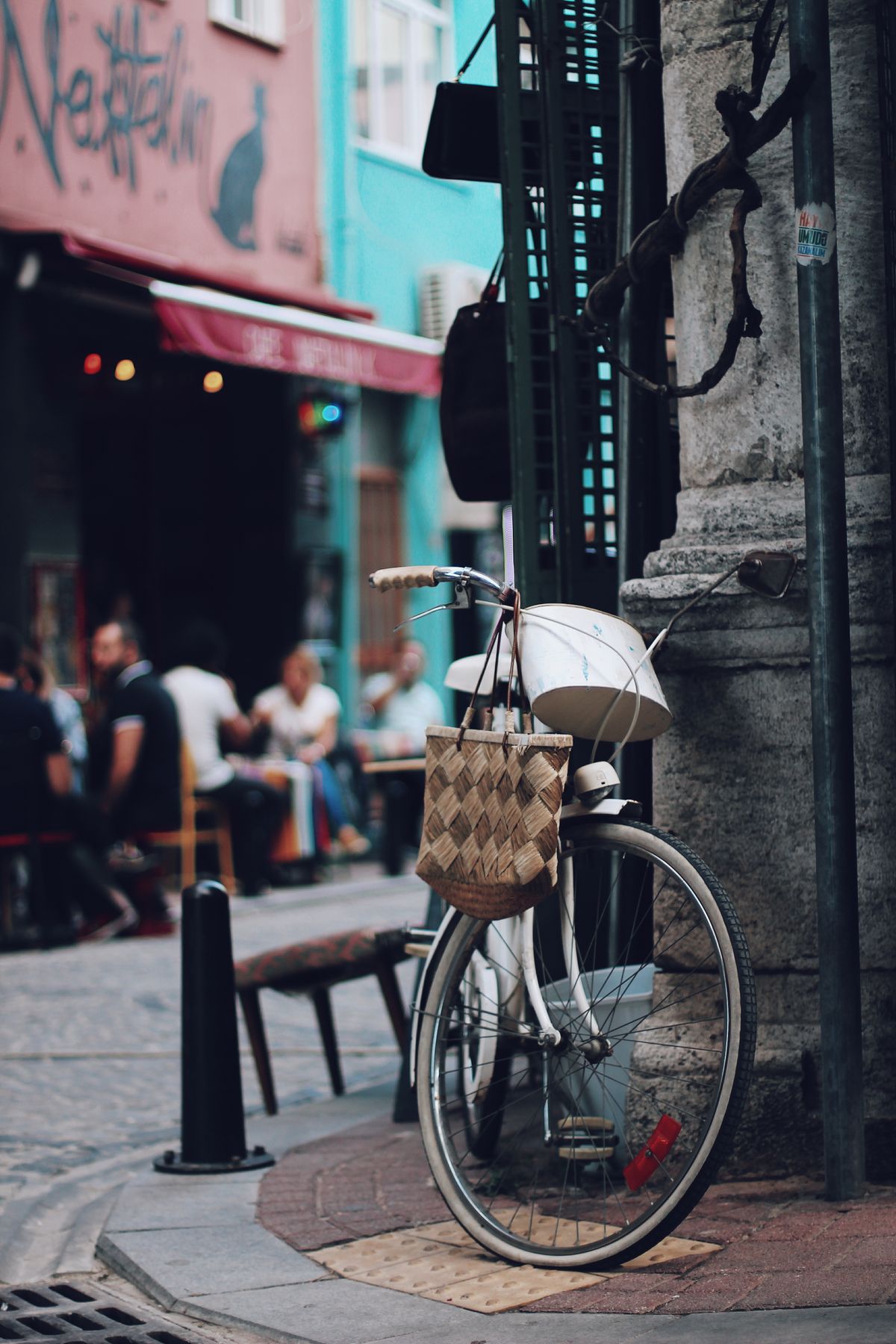 City bicycle with a basket parked near an outdoor cafe