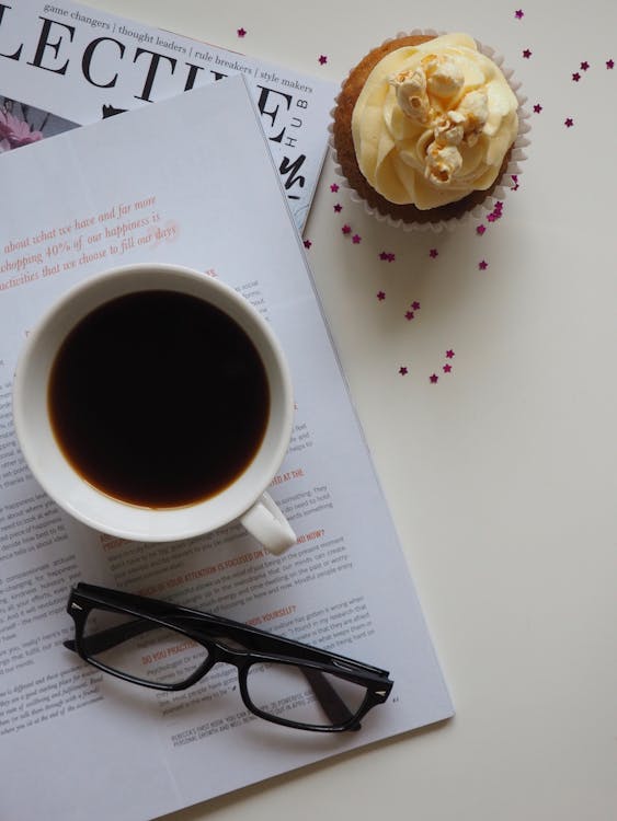 Free White Ceramic Cup With Coffee on Top of Opened Book and Near Eyeglasses Stock Photo