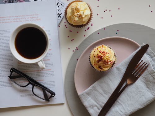 Free Top-view Photograph of Two Cupcakes, Cup, and Eyeglasses Stock Photo