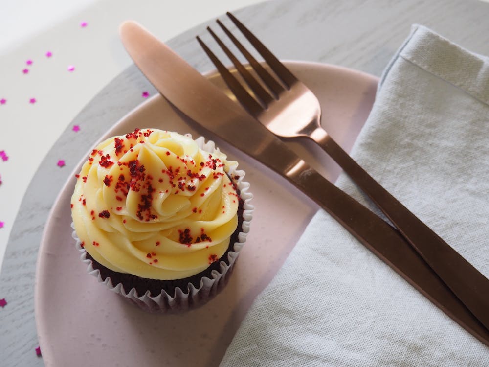 Garpu Perak Dan Pisau Di Piring Bulat Dengan Cupcake