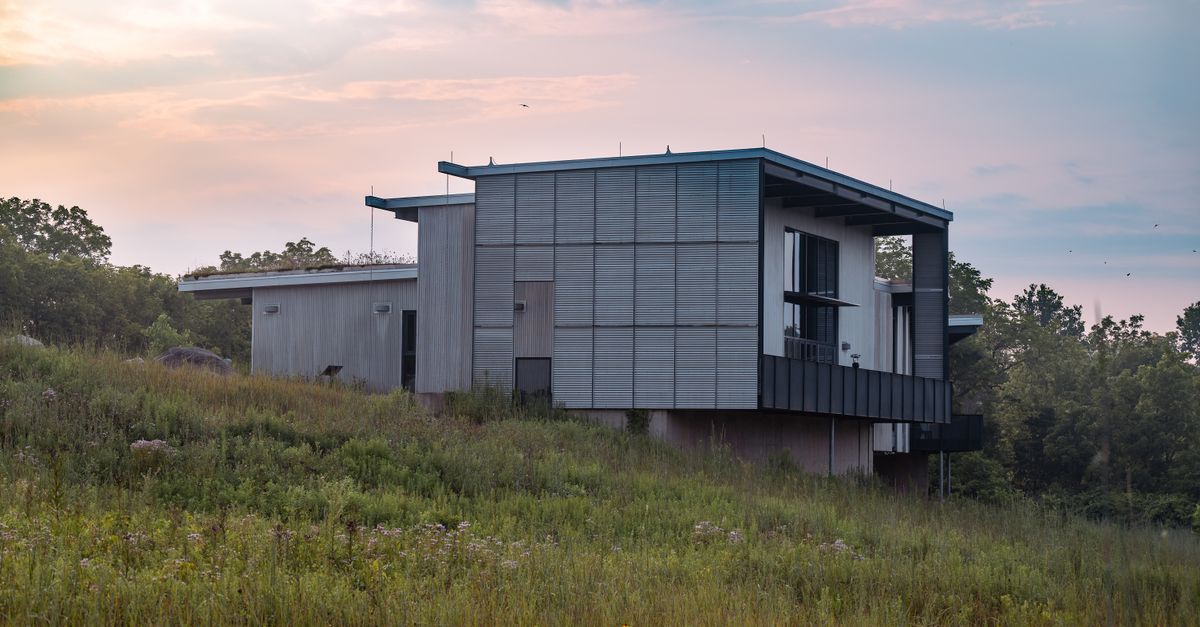 A contemporary home nestled in a peaceful grassland setting during a serene evening.