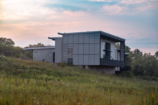 Low contemporary house set in open grassland at dusk — photo by Chris F on Pexels