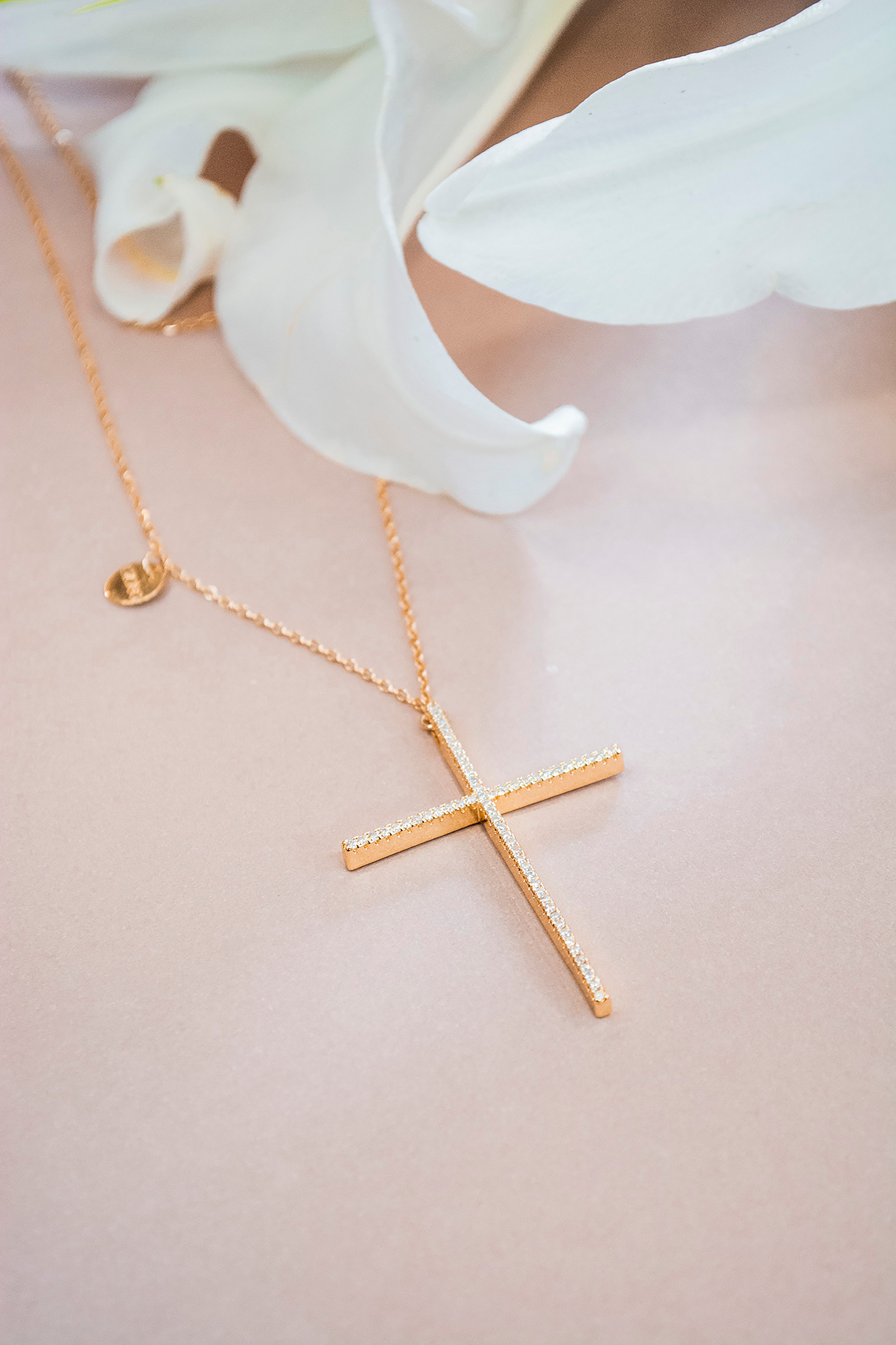 Gold cross necklace styled with a white lily