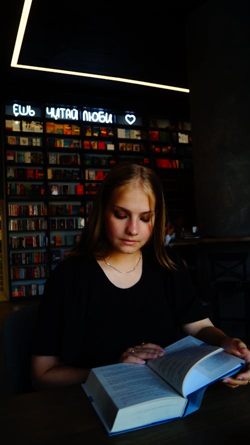 Beautiful Woman Reading a Book at the Library