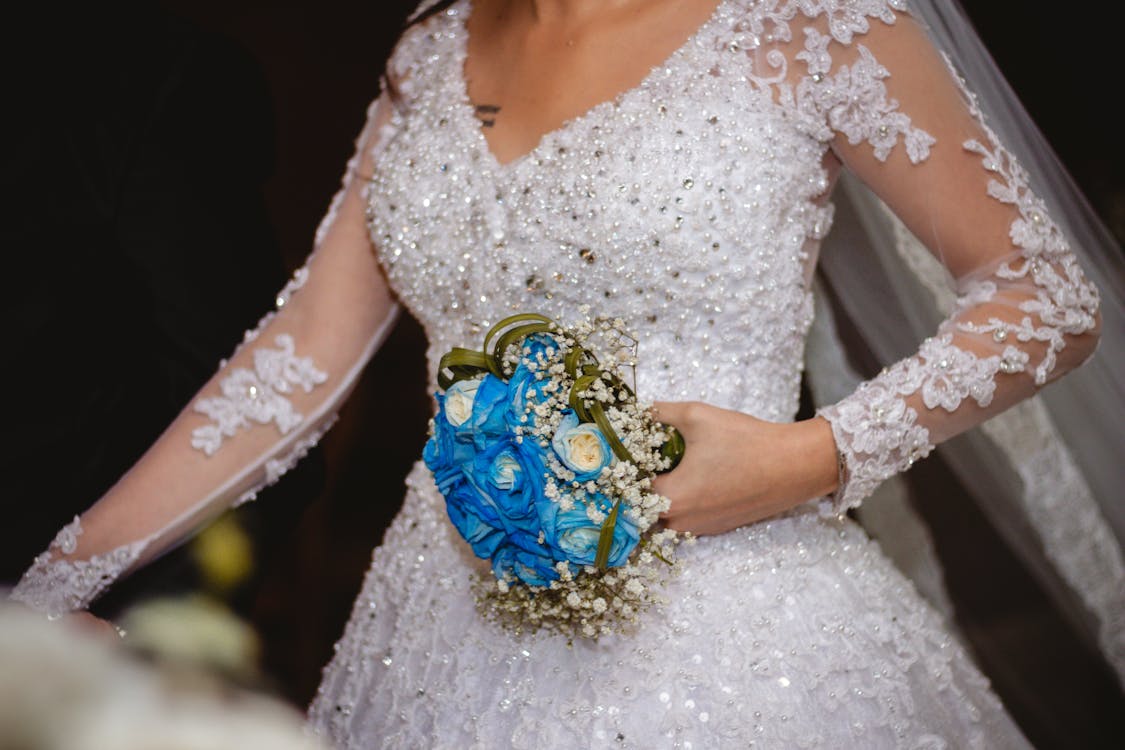 Woman in Bridal Gown Holding Boquet of Flowers