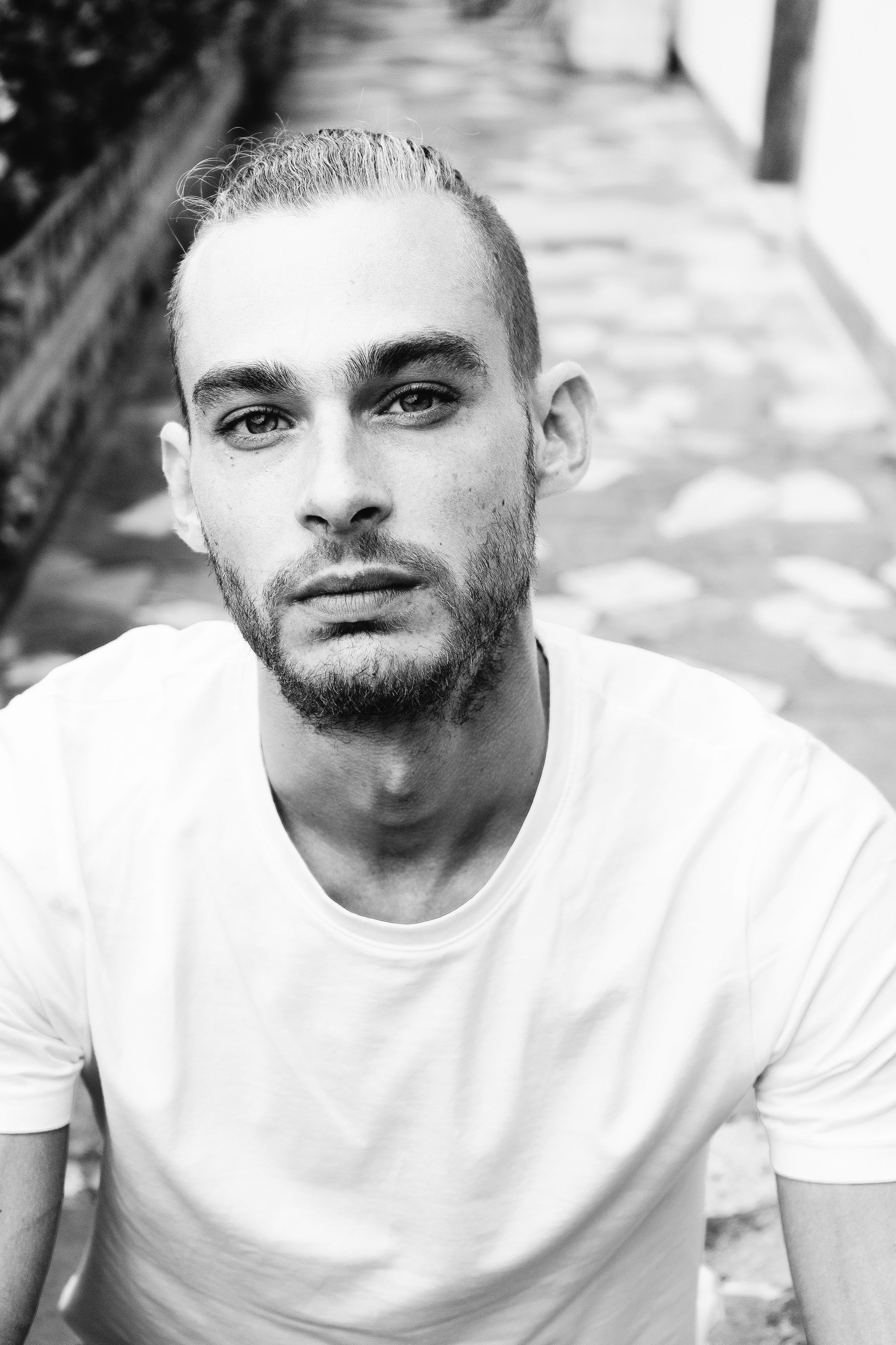 Expressive black and white portrait of a young man with a contemplative gaze.